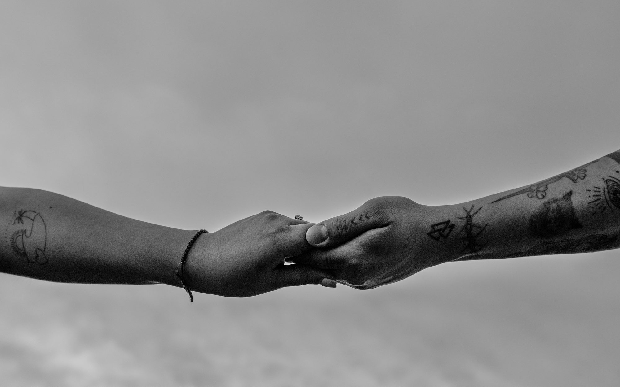 Manos entrelazadas de los novios, fotografía en blanco y negro